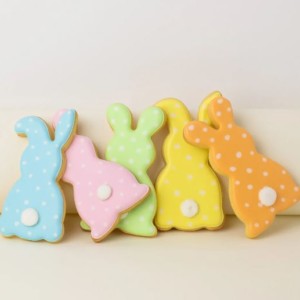 A photo of some biscuits in the shape of bunny rabbits. They are decorated with coloured icing.