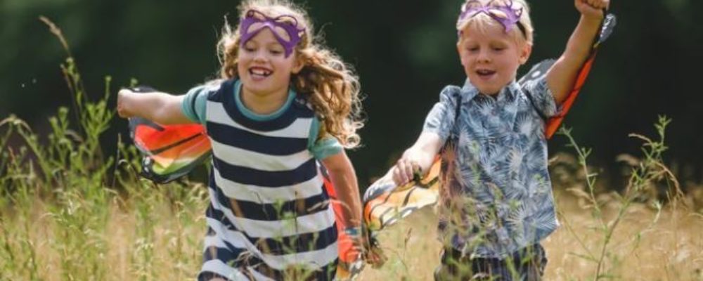 A photograph of a boy and a girl running in a field.