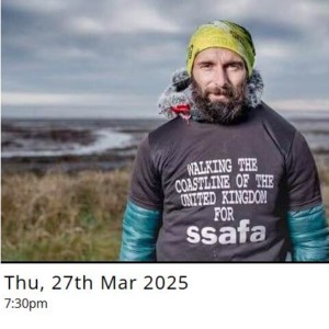 Photograph of Christian Lewis. He is a bearded man with a yellow headband and he has a t-shirt on that says 'walking the coastline of the United Kingdom for SSAFA